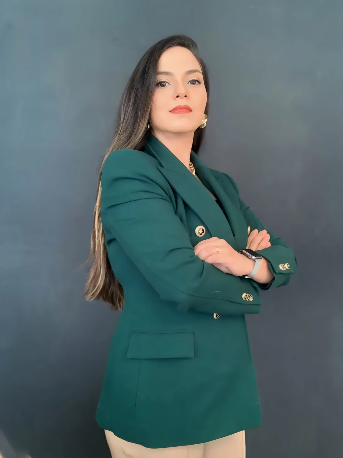 Dra. Gicelli Paixão, de braços cruzados, vestindo blazer verde